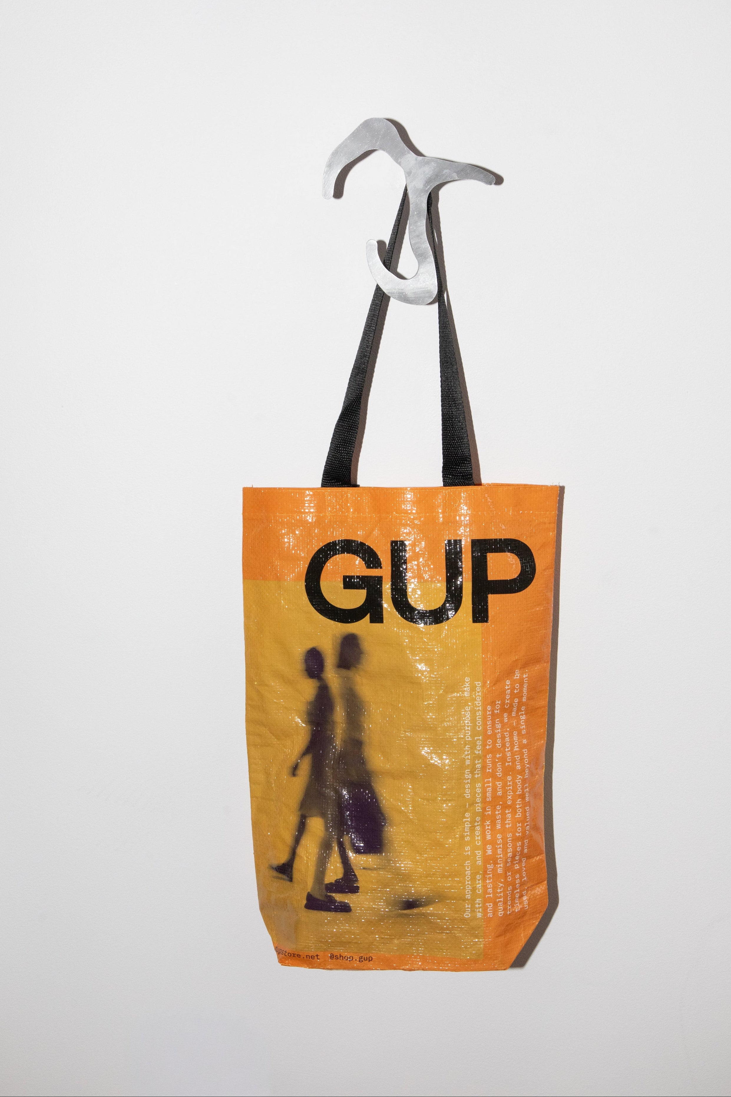 Orange tote bag with 'GUP' text and graphic on a white background